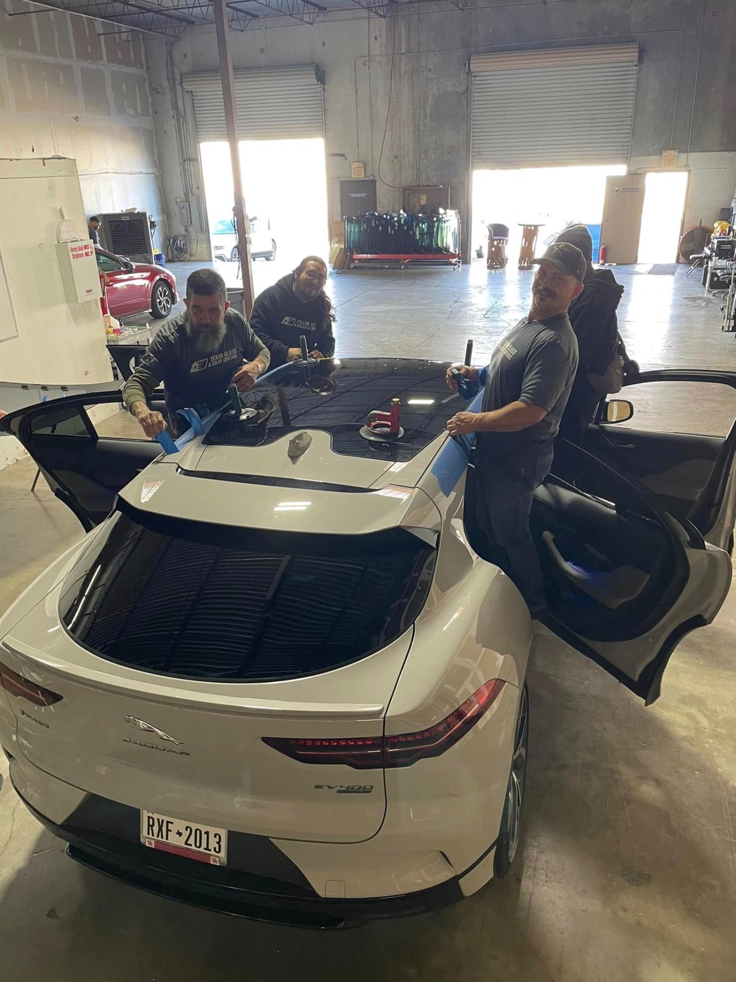 Our team performing a windshield replacement on a Jaguar EV